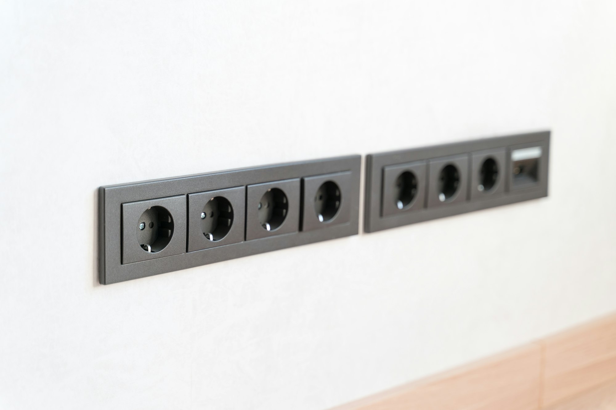 Brown electrical sockets on the white wall of the apartment