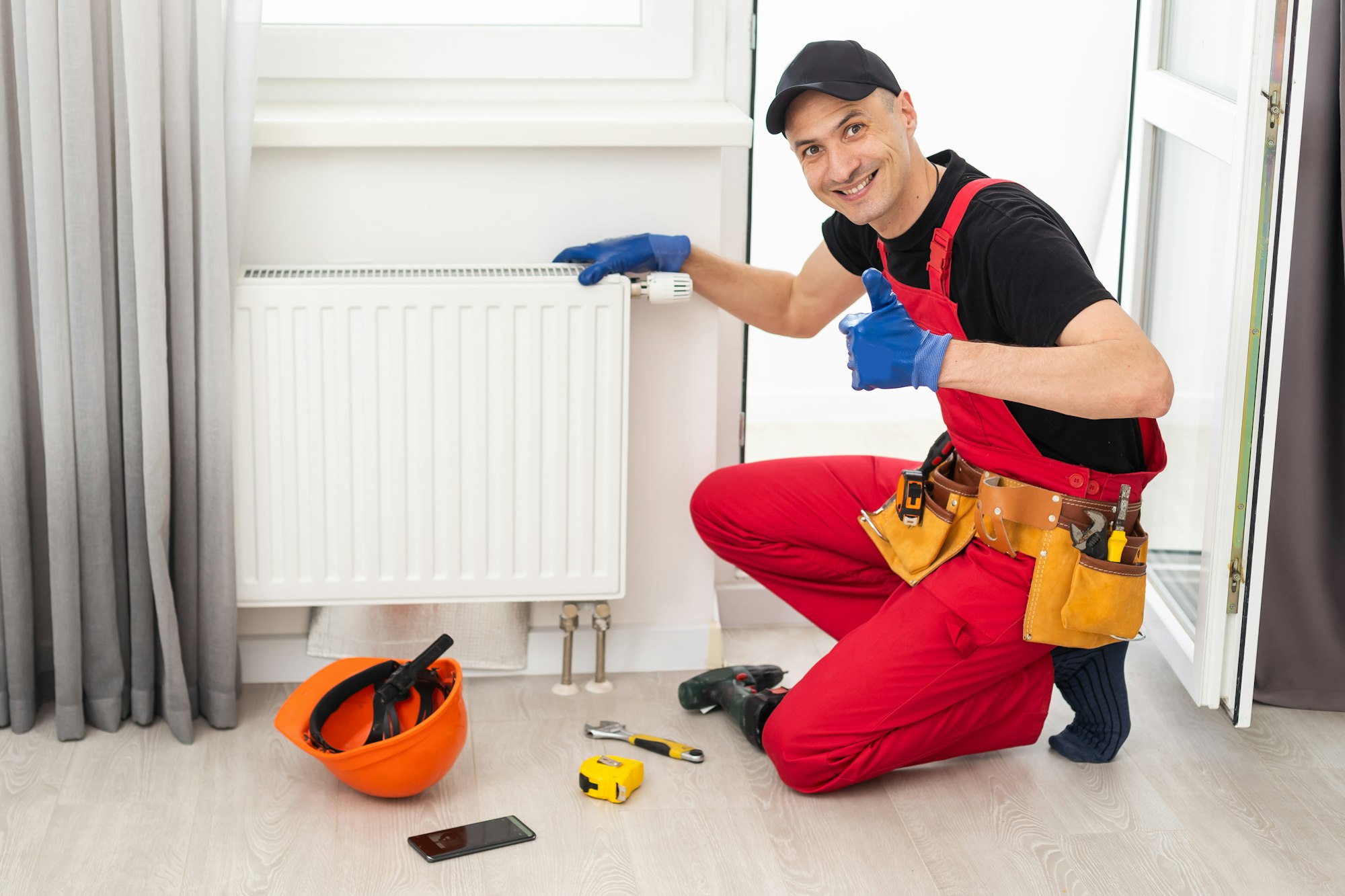 plumber at work. Installing water heating radiator